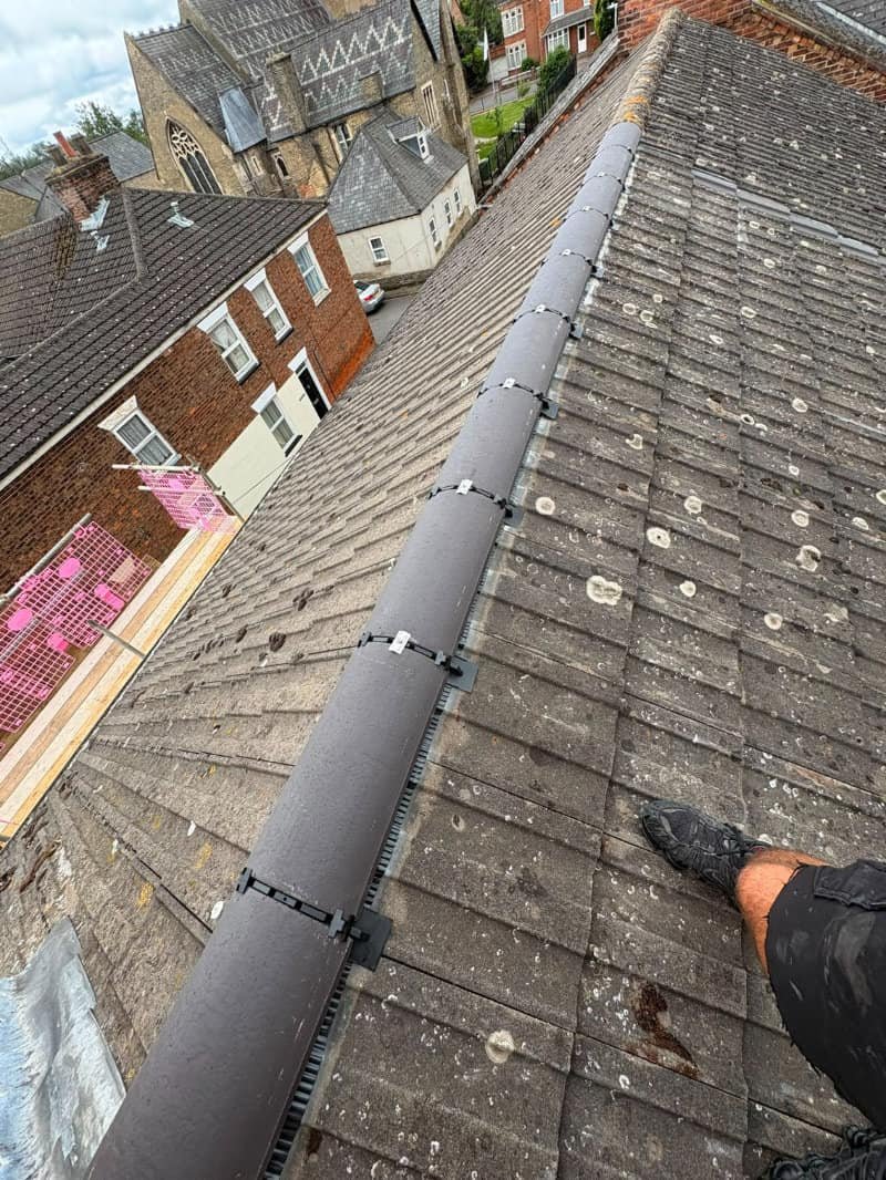 New dry ridge tiles fitted along a roof in Norwich