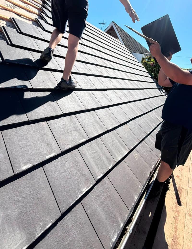 Two Norwich Roofing Company roofers fitting a new slate roof in Norwich
