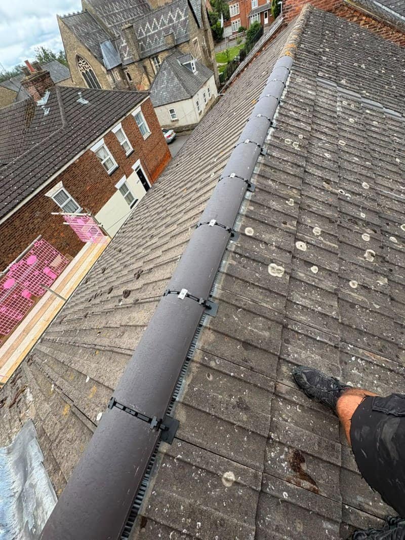New dry ridge tiles fitted along a roof in Dereham