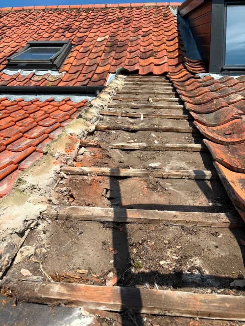 Line of missing tiles on a red tiled roof in North Walsham during a repair